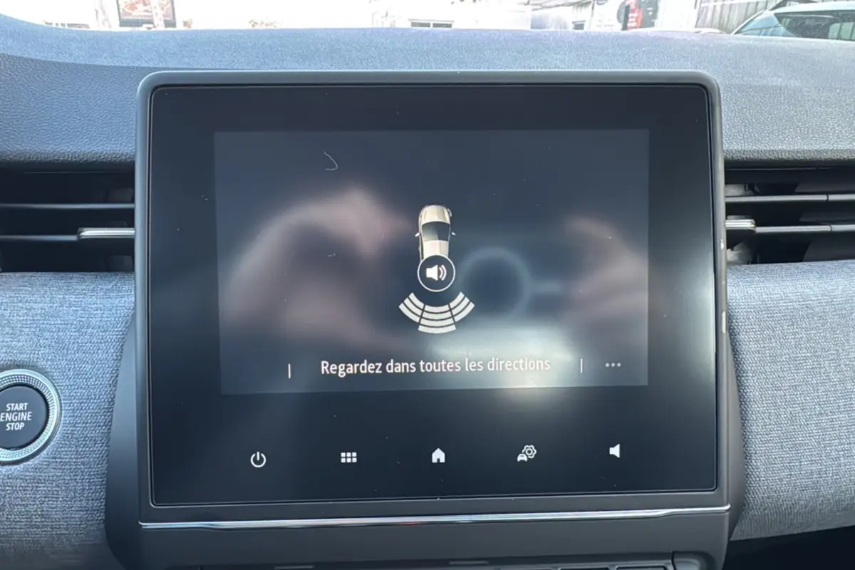 Écran tactile central du tableau de bord de la Renault Clio 2025, affichant une alerte de surveillance des angles morts.