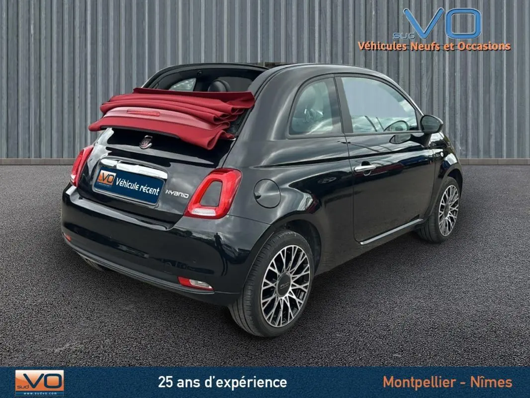 Fiat 500C noire vue 3/4 arrière droit avec toit rouge replié, jantes stylées et roue de secours visible