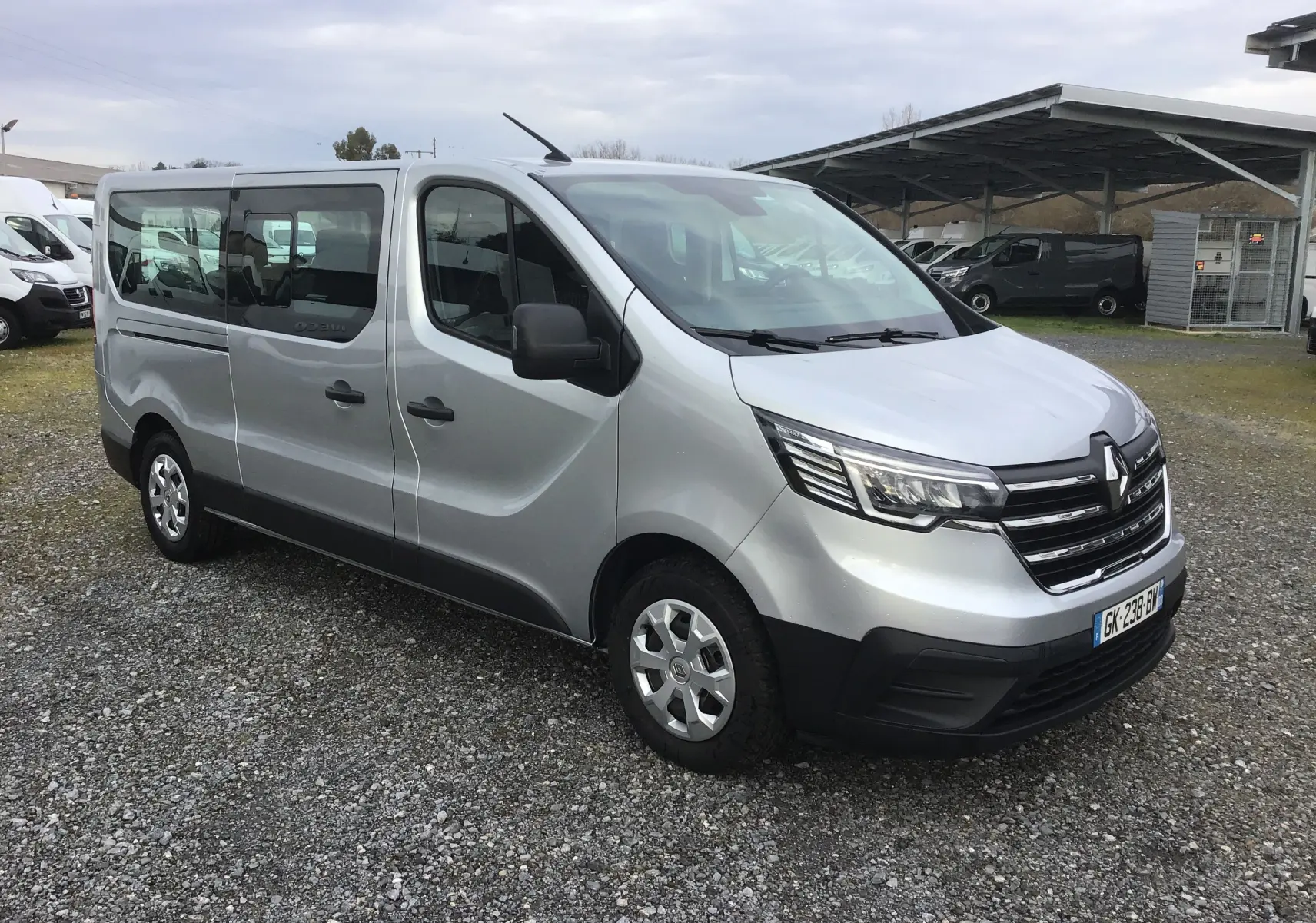Renault Trafic Combi gris Highland en vue 3/4 avant droit, avec calandre noire et vitres latérales teintées.