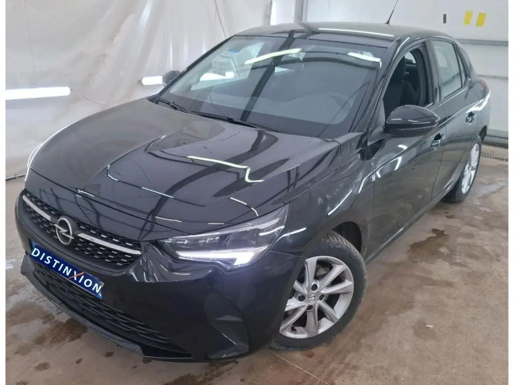 Vue 3/4 avant droite d'une Opel Corsa 2023 noir perla avec phares allumés et jantes alliage visibles.
