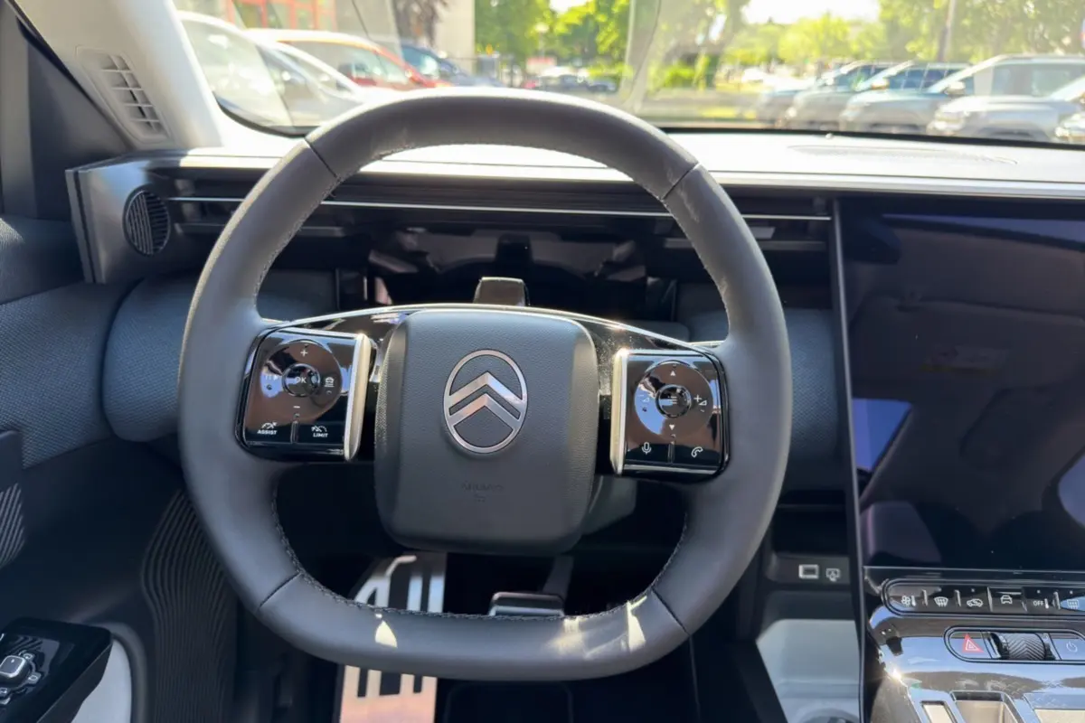 Vue frontale du volant cuir multifonctions noir avec logo Citroën, entouré de commandes intégrées et tableau de bord moderne.