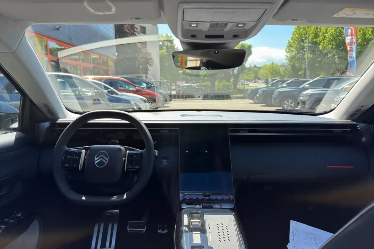 Vue intérieure frontale du Citroën C5 Aircross 2026, tableau de bord noir avec grand écran tactile central et volant multifonctions.