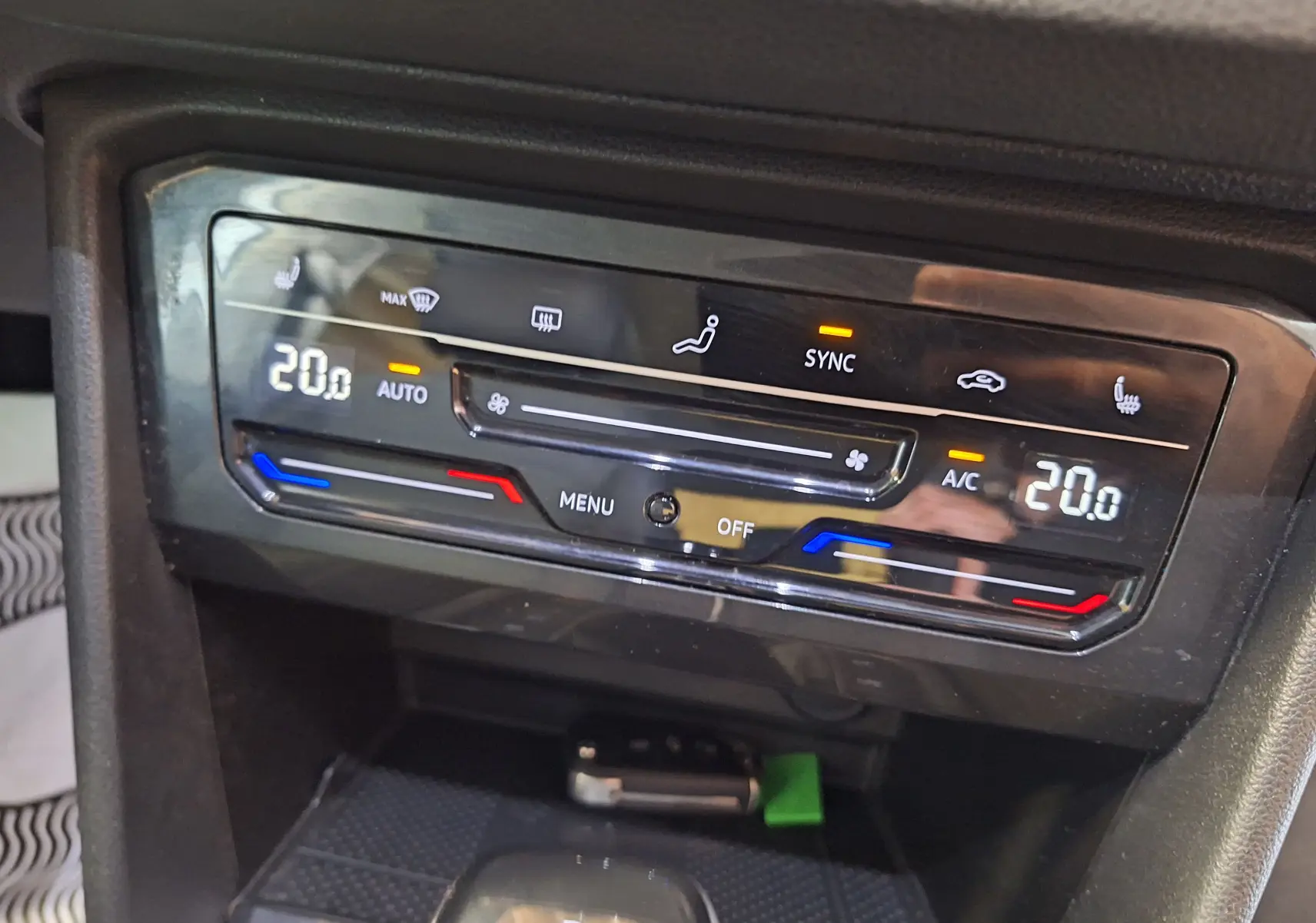 Panneau de climatisation digital du Volkswagen Tiguan gris, affichant 20°C en mode automatique avec fonction SYNC active.