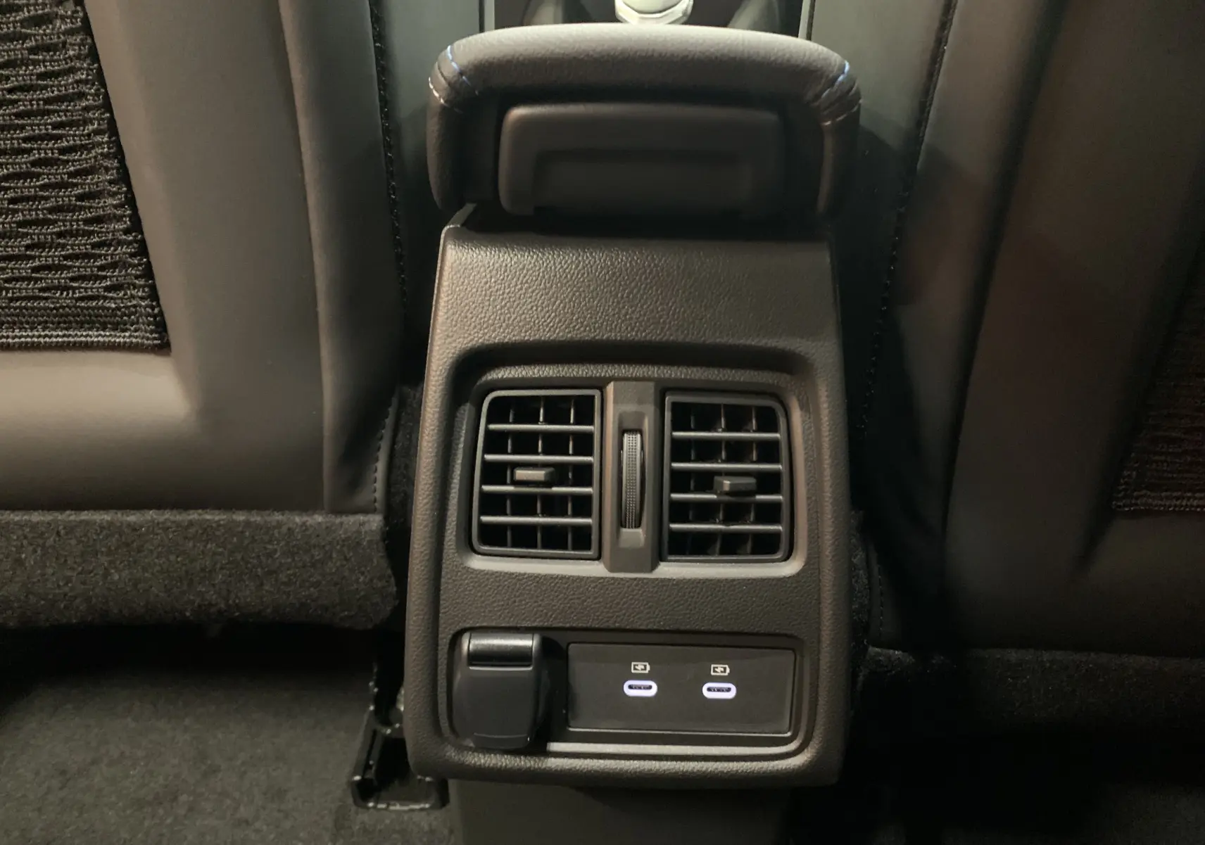 Vue rapprochée des aérateurs arrière et des deux ports USB-C illuminés sur la console centrale d'une Renault Symbioz 2025.