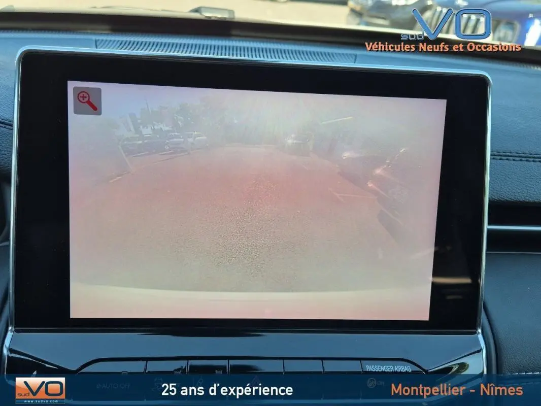 Écran tactile intérieur montrant la caméra de recul du Jeep Compass blanc 2023, tableau de bord noir moderne.