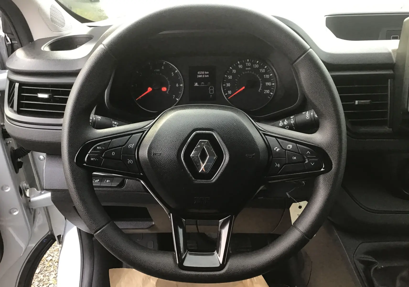 Vue rapprochée du volant noir du Renault Trafic Combi 2023 avec tableau de bord et commandes visibles.