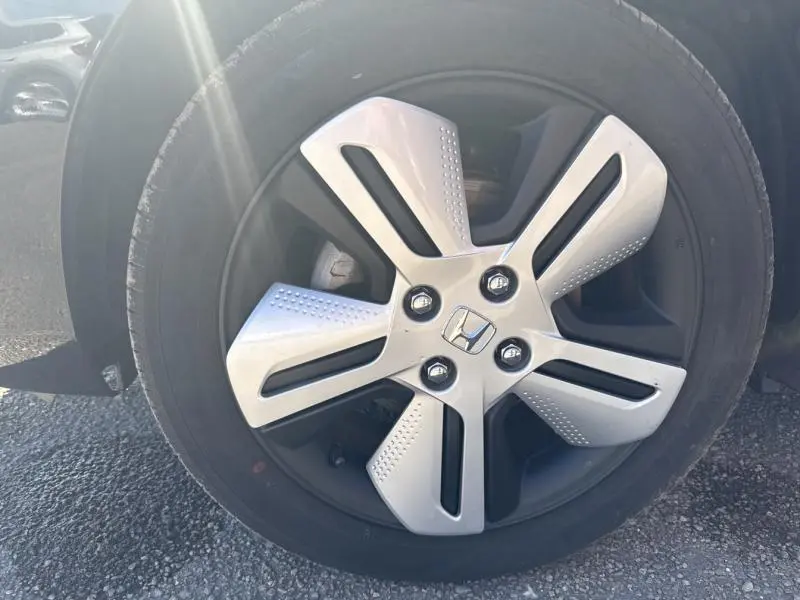 Gros plan sur la jante alu 5 branches bicolore du côté gauche d'une Honda Jazz Bleu Nuit Radiant nacré 2021.