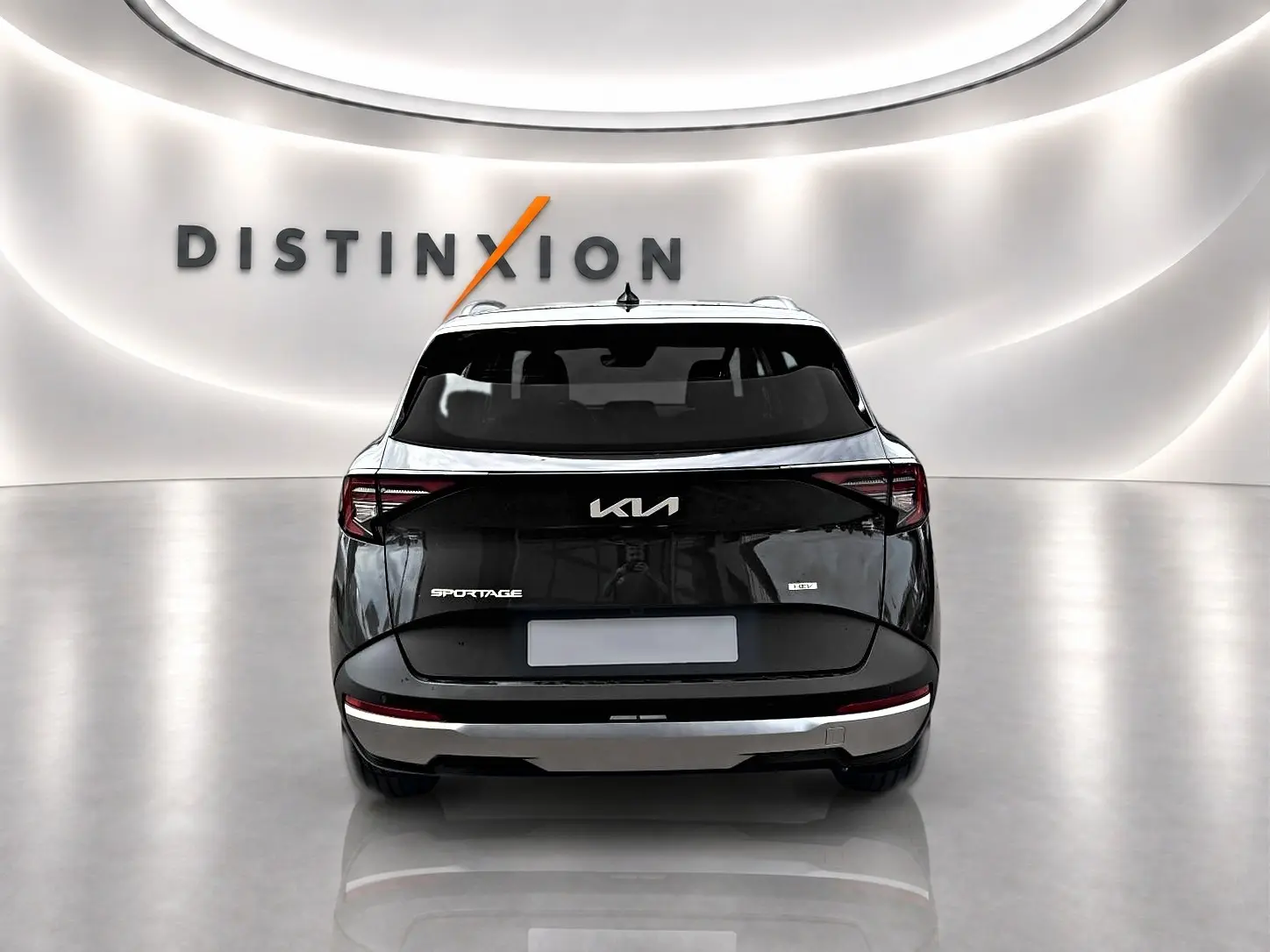 Vue arrière d'un KIA SPORTAGE 1.6 hybride gris eclipse, avec feux arrière LED et logo KIA lumineux.