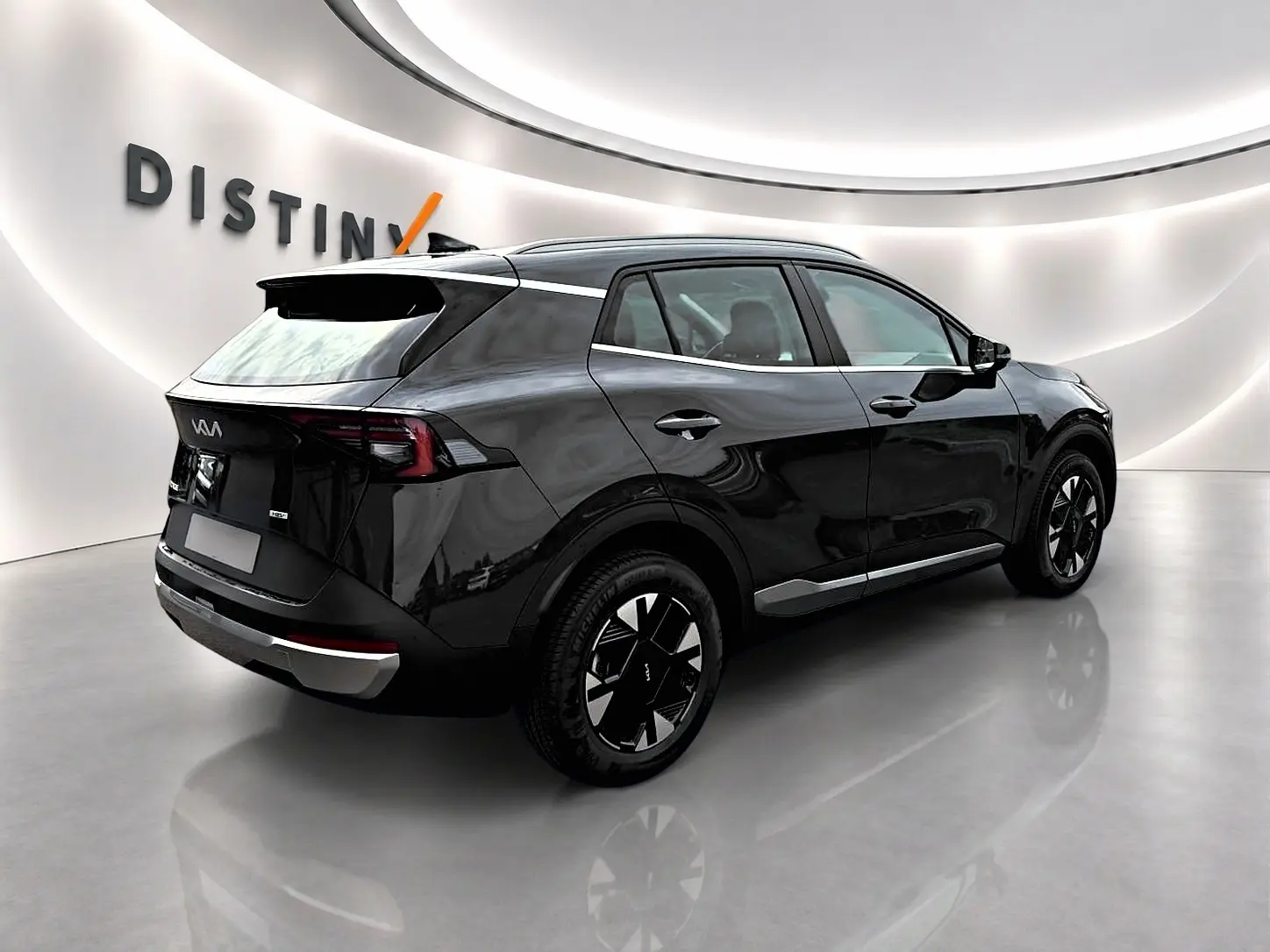 Vue 3/4 arrière droite du KIA SPORTAGE 1.6 hybride 239 en noir brillant avec jantes alu et becquet arrière.