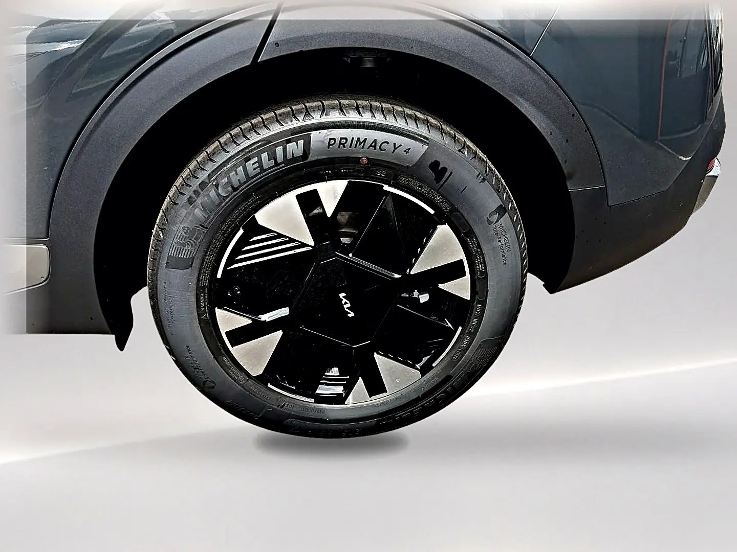 Gros plan sur la roue arrière droite gris eclipse du KIA SPORTAGE 1.6 hybride 239 avec jante alu noire et argent.