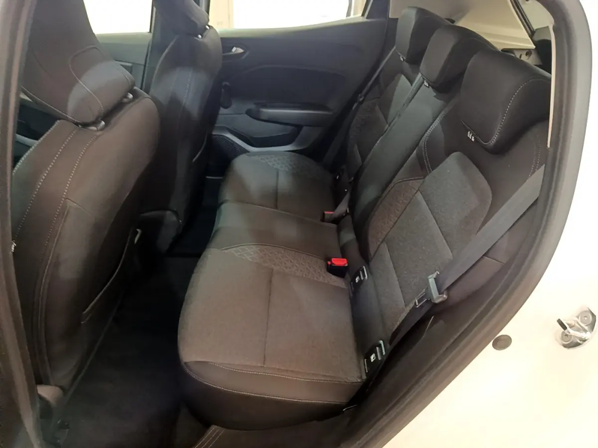 Vue latérale droite de l'habitacle arrière de la Renault Clio Business blanche, sièges tissu noir avec surpiqûres contrastées.