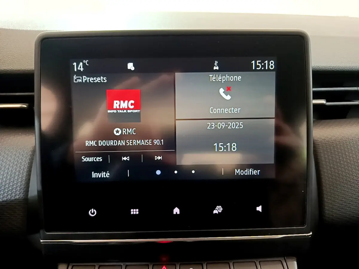 Écran tactile central de la Renault Clio Business blanc 2021 affichant la radio RMC et options téléphone à 15h18.