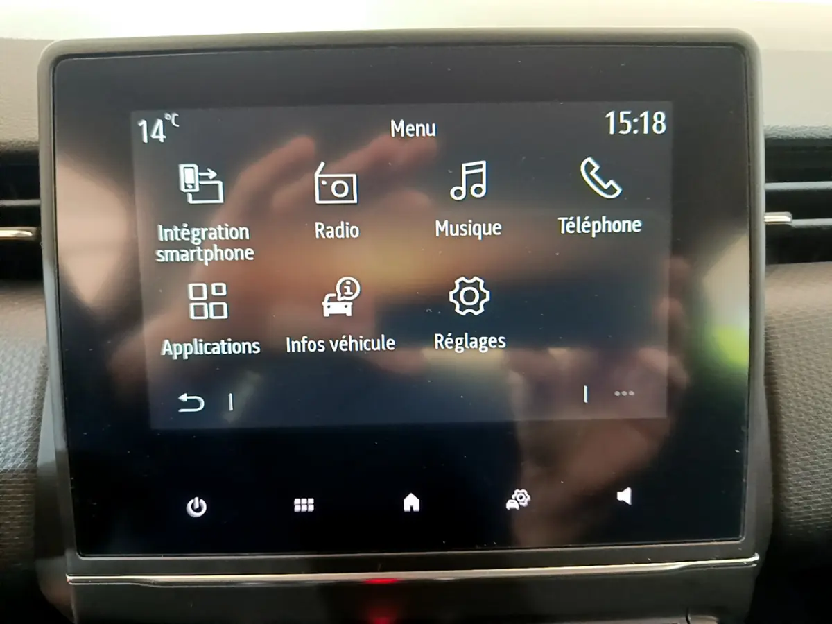 Écran tactile central de la Renault Clio Business blanc 2021 affichant le menu multimédia avec options smartphone et radio.