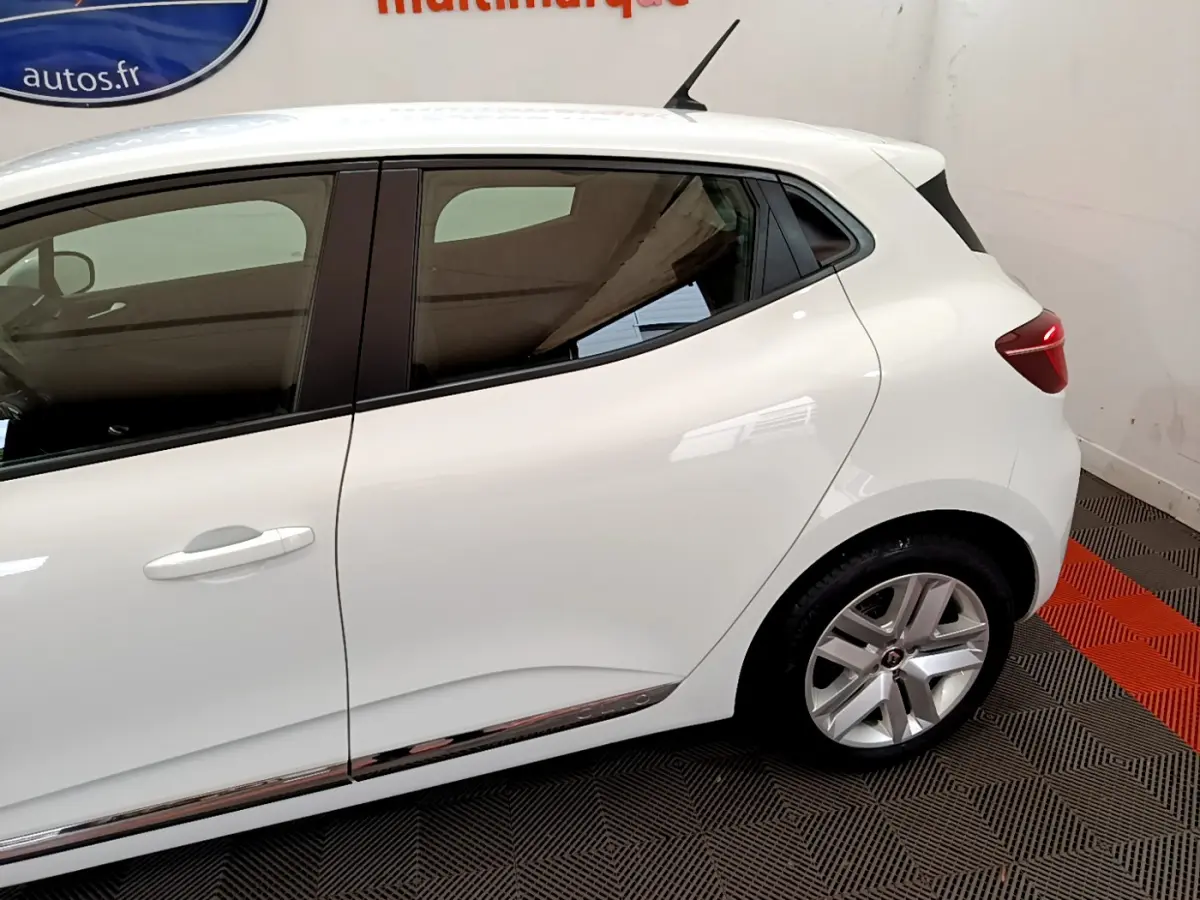 Profil côté droit de la Renault Clio Business blanche de 2021, mettant en valeur la ligne fluide et les jantes alliage.