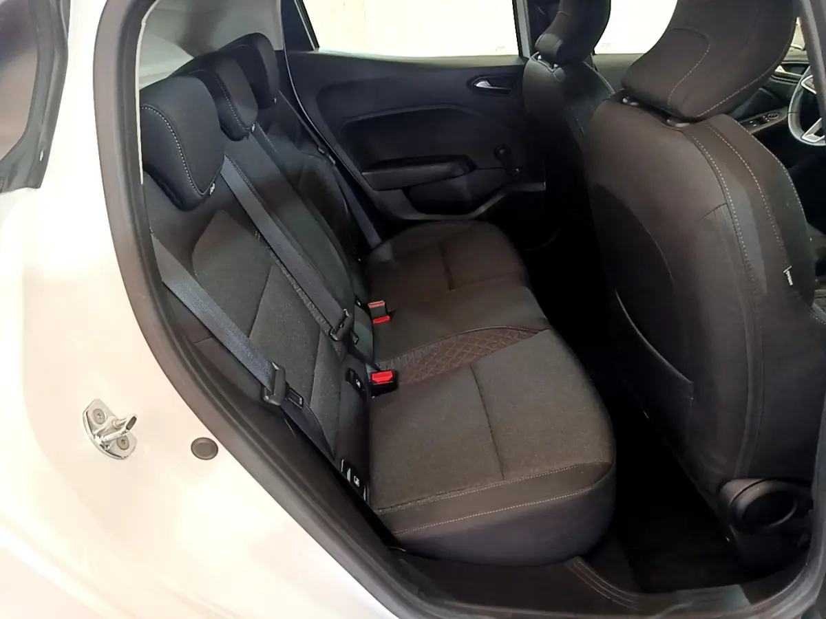 Vue intérieure arrière droite de la Renault Clio Business blanche, sièges tissu gris foncé avec ceinture de sécurité visible.