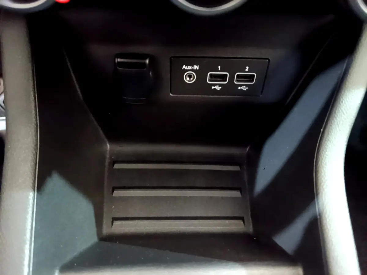 Gros plan sur la console centrale noire de la Renault Clio Business avec ports USB et entrée Aux-In visibles.