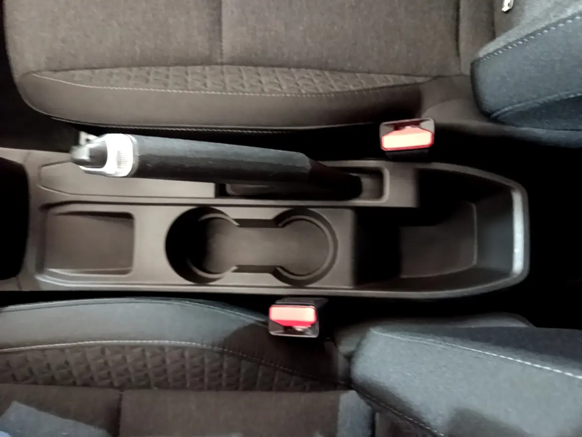 Vue plongeante sur la console centrale noire avec frein à main et porte-gobelets de la Renault Clio Business blanche 2021