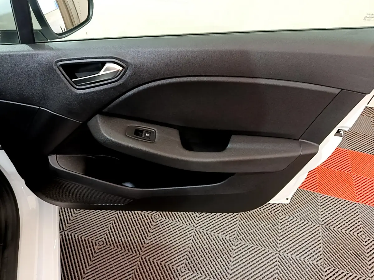 Vue intérieure sur la porte avant gauche noire d'une Renault Clio Business blanche, avec poignée et commande de fenêtre.