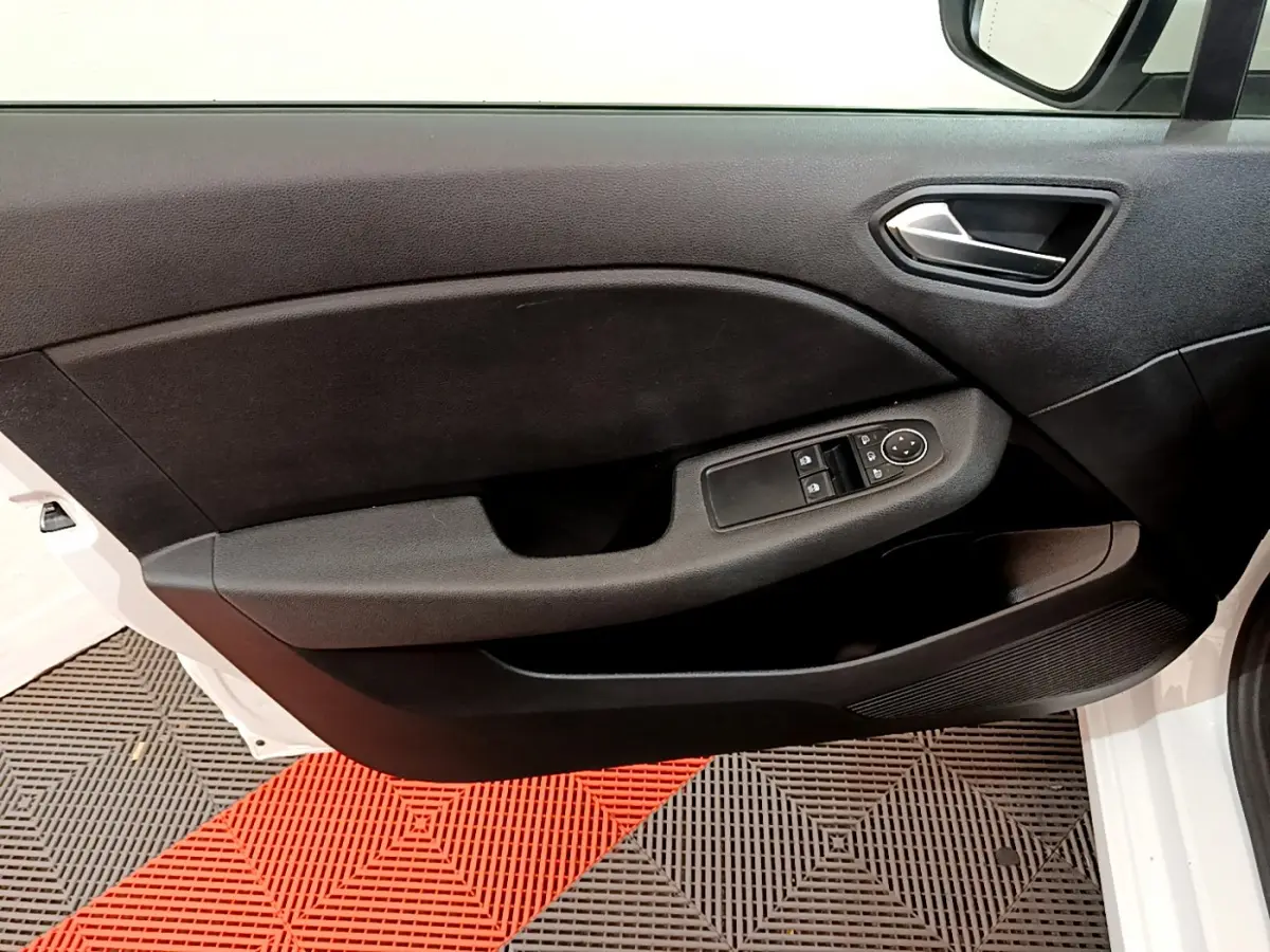 Porte côté gauche ouverte de la Renault Clio Business blanche 2021, avec commandes des vitres et rétroviseurs visibles.