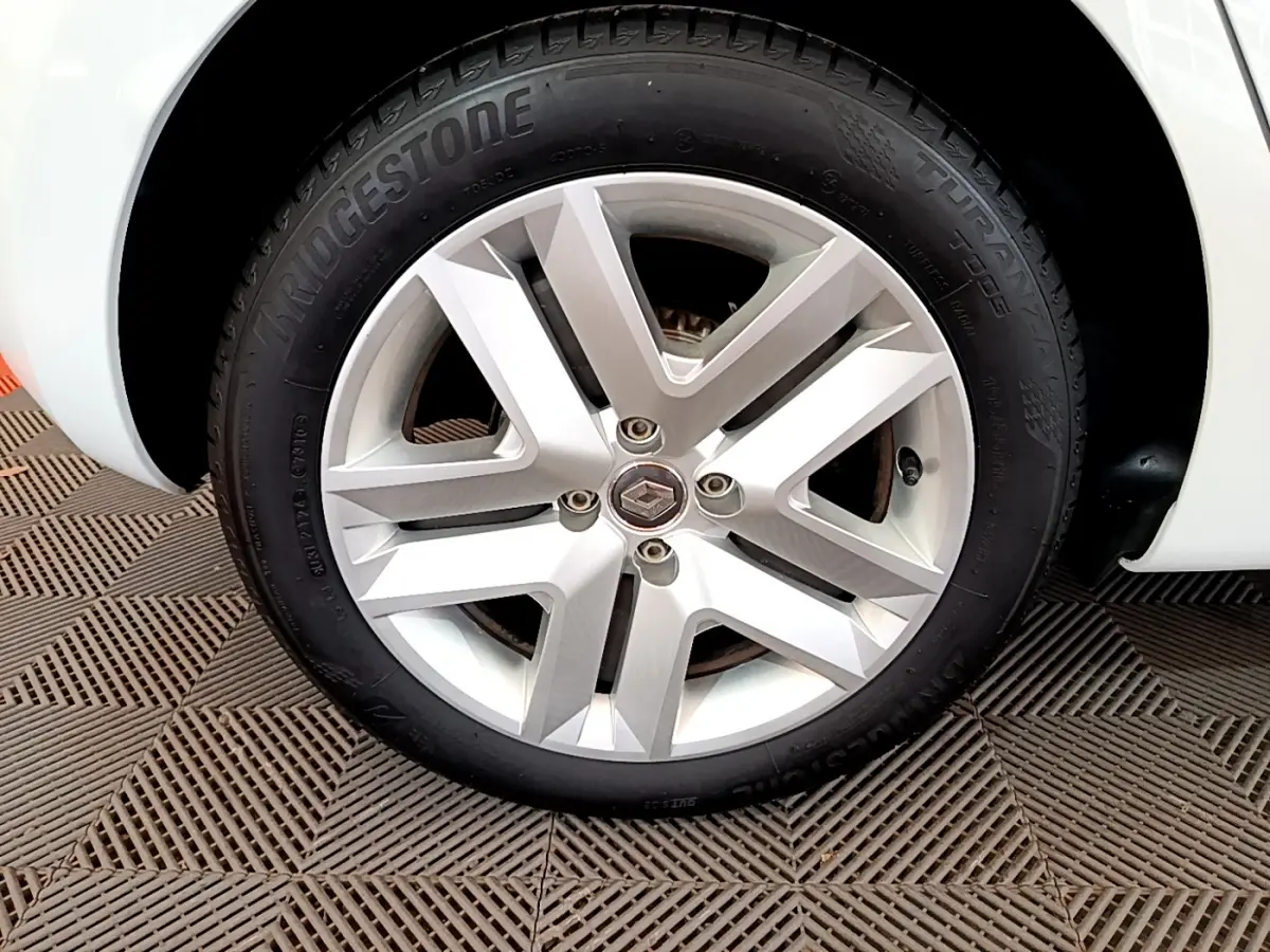 Gros plan sur la roue avant droite blanche d'une Renault Clio Business 2021 avec jante alliage et pneu Bridgestone.