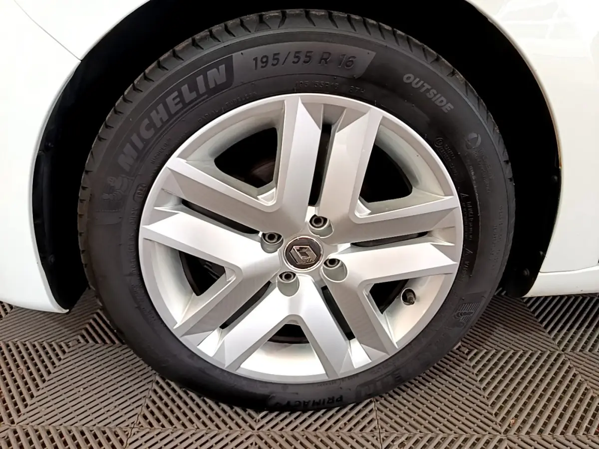 Gros plan sur la roue arrière droite d'une Renault Clio Business blanche de 2021, avec partie de la carrosserie visible.