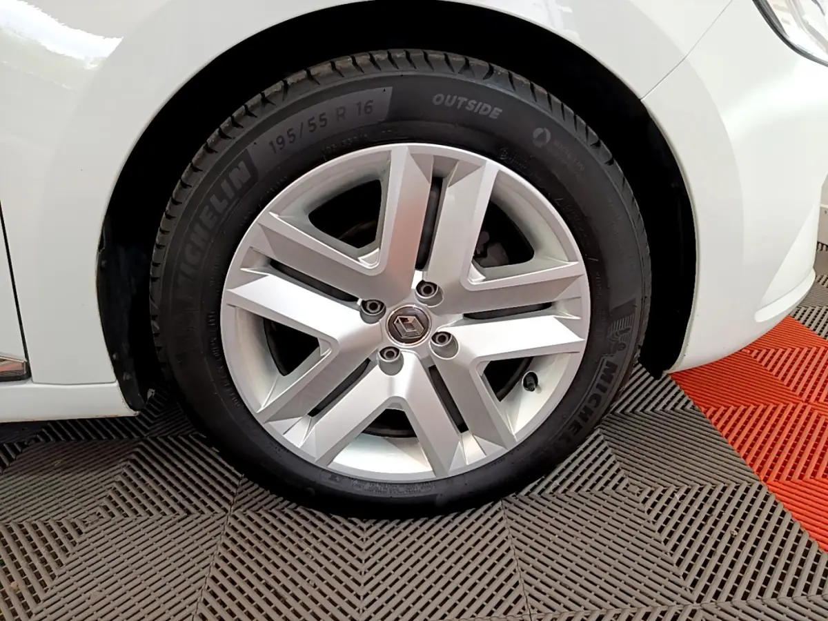 Gros plan sur la roue avant droite de la Renault Clio Business blanche, mettant en valeur la jante alliage et le pneu Michelin.