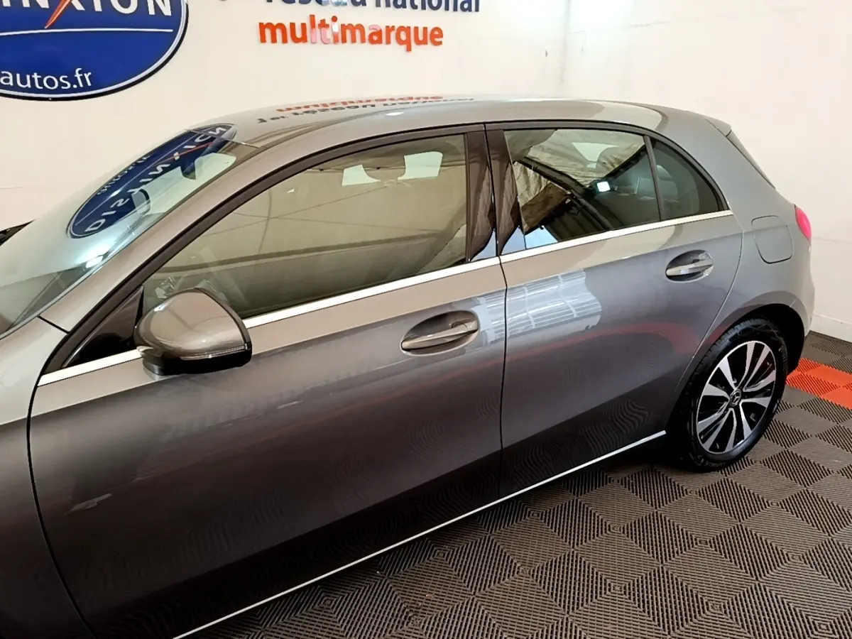 Vue de profil côté gauche d'une Mercedes Classe A 250 e Business Line gris métallisé avec jantes alliage et rétroviseurs intégrés.