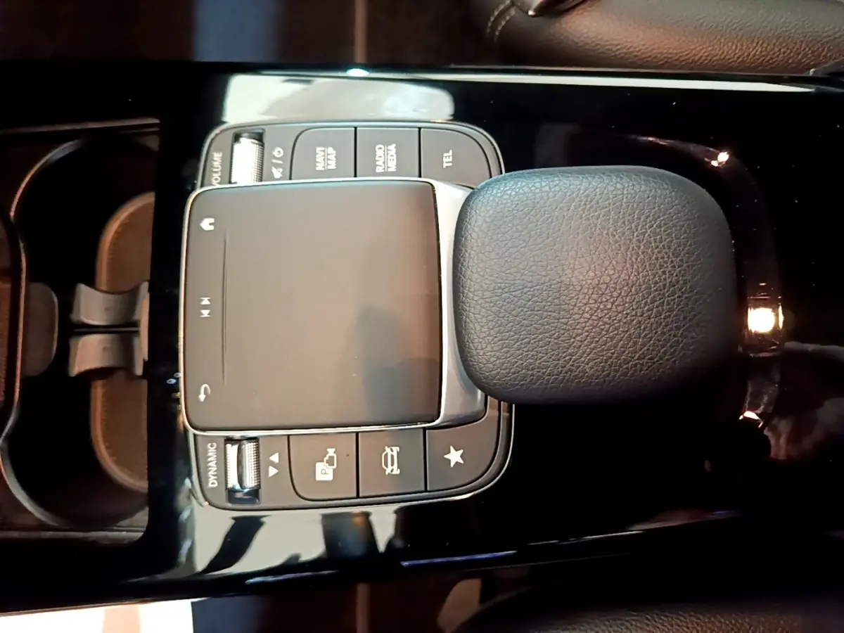 Vue rapprochée du pavé tactile et du repose-poignet en cuir noir de la console centrale d'une Mercedes Classe A 250 e Business Line.