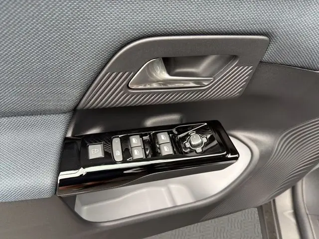 Gros plan sur la commande des vitres et rétroviseurs côté conducteur du Citroën C5 Aircross gris platinium, intérieur tissu bleu.