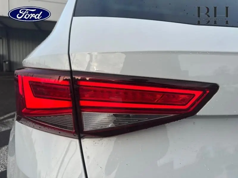 Gros plan sur le feu arrière droit rouge d’un SEAT Ateca blanc Nevada Métal, avec détails nets et carrosserie brillante.