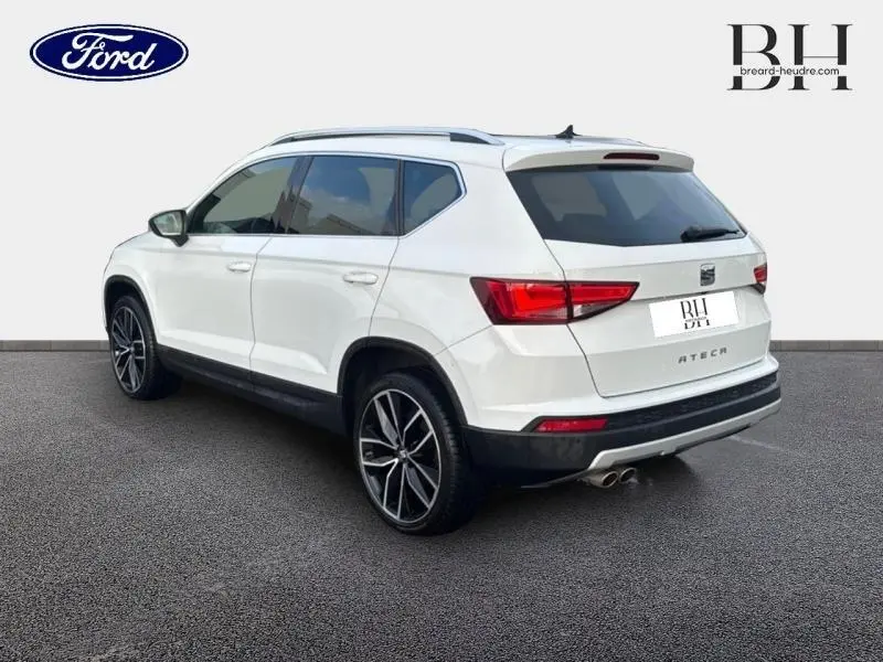 Vue 3/4 arrière droite d'un SEAT Ateca blanc Nevada Métal avec jantes alliage et double sortie d'échappement chromée.