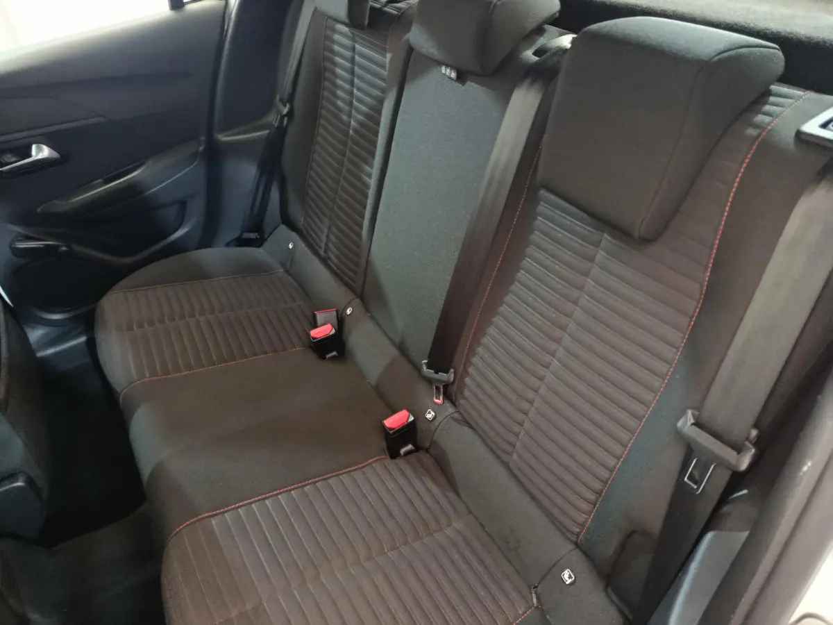 Banquette arrière noire avec surpiqûres rouges de la Peugeot 208 PureTech 100 vue côté gauche intérieur arrière.