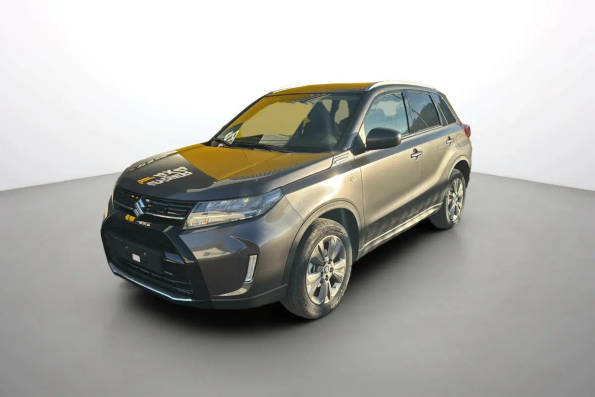 Suzuki Vitara Hybrid 110 Privilège Allgrip gris Titan en 3/4 avant droit avec jantes alu et feux LED allumés.
