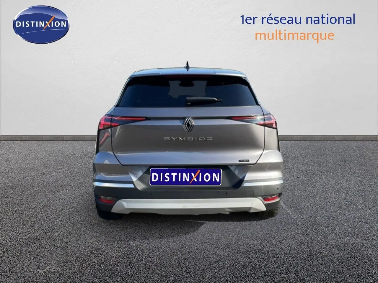 Vue arrière d'une Renault Symbioz gris cassiopée métal avec feux arrière fins et logo central visible.