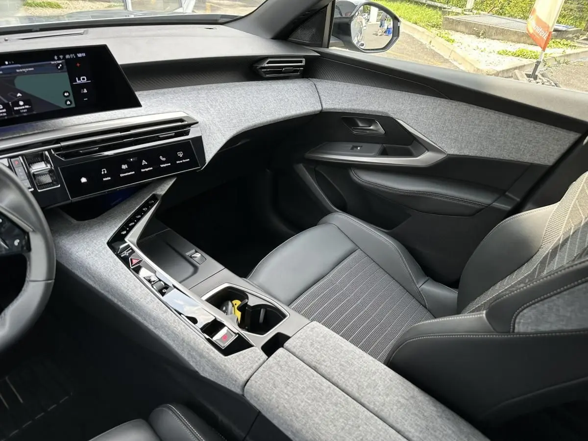 Intérieur avant droit du Peugeot 3008 2024 gris Artense, avec tableau de bord tissu gris et écran tactile panoramique.