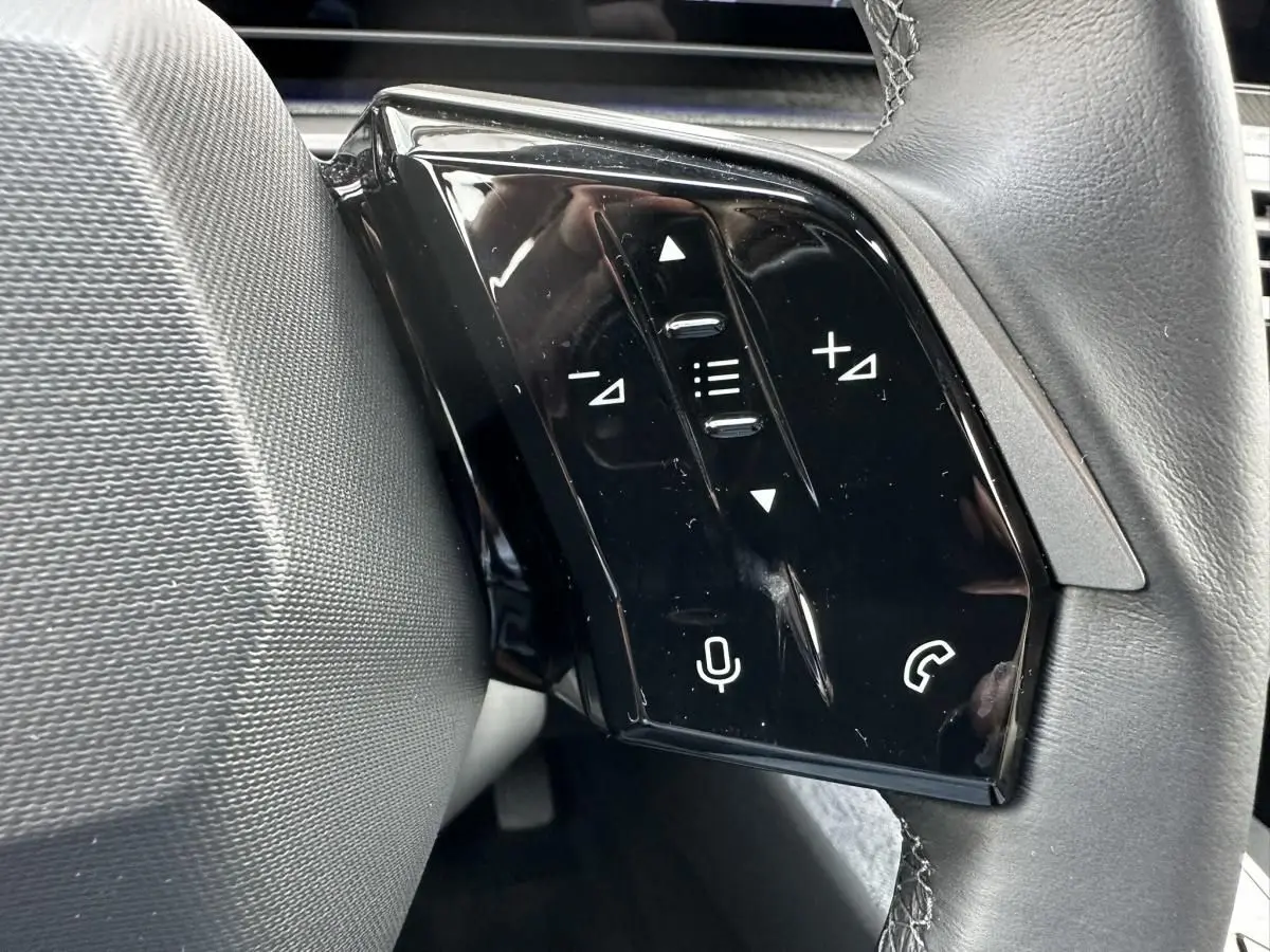 Gros plan sur les commandes tactiles noires à gauche du volant du Peugeot 3008 2024 gris Artense.