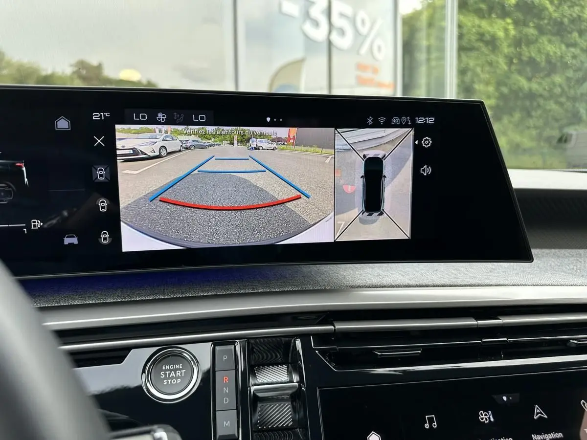 Vue intérieure du tableau de bord du Peugeot 3008 gris Artense, écran affichant la caméra de recul et la vue à 360° en marche arrière.