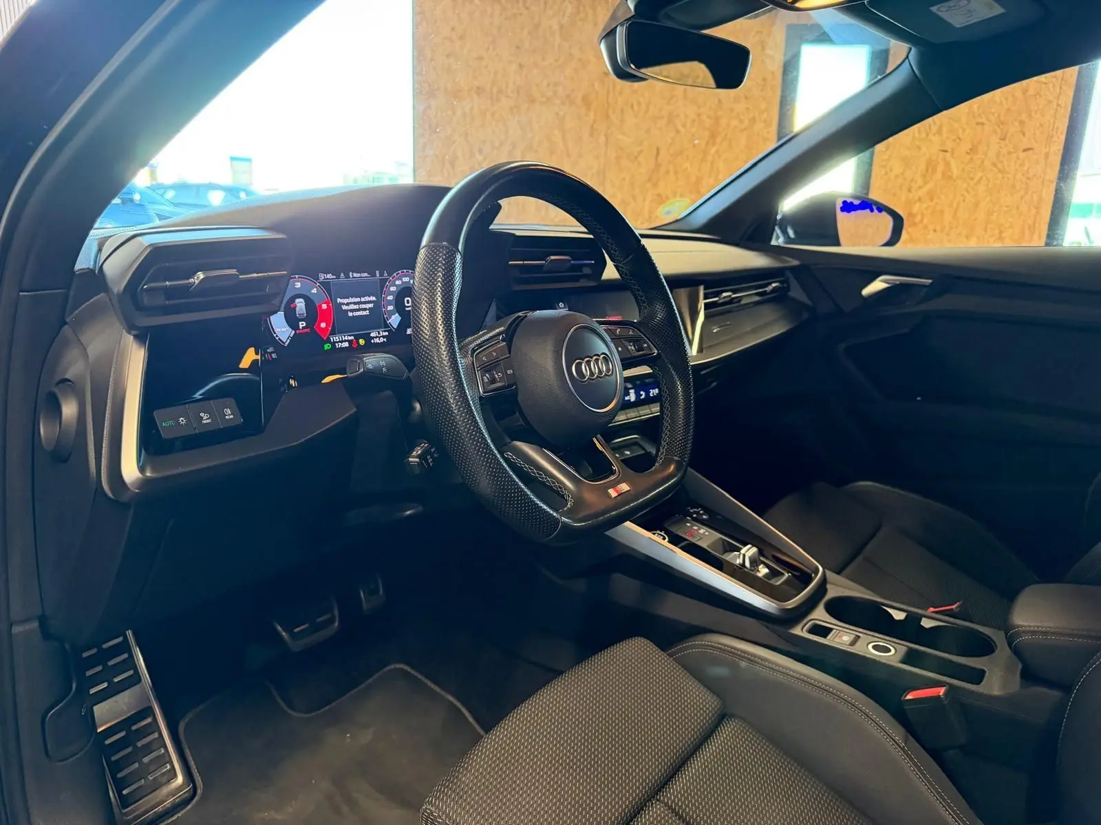 Vue intérieure côté conducteur de l'Audi A3 2.0 TDI 150 S-TRONIC S-LINE 2022 avec volant sport et tableau de bord numérique.