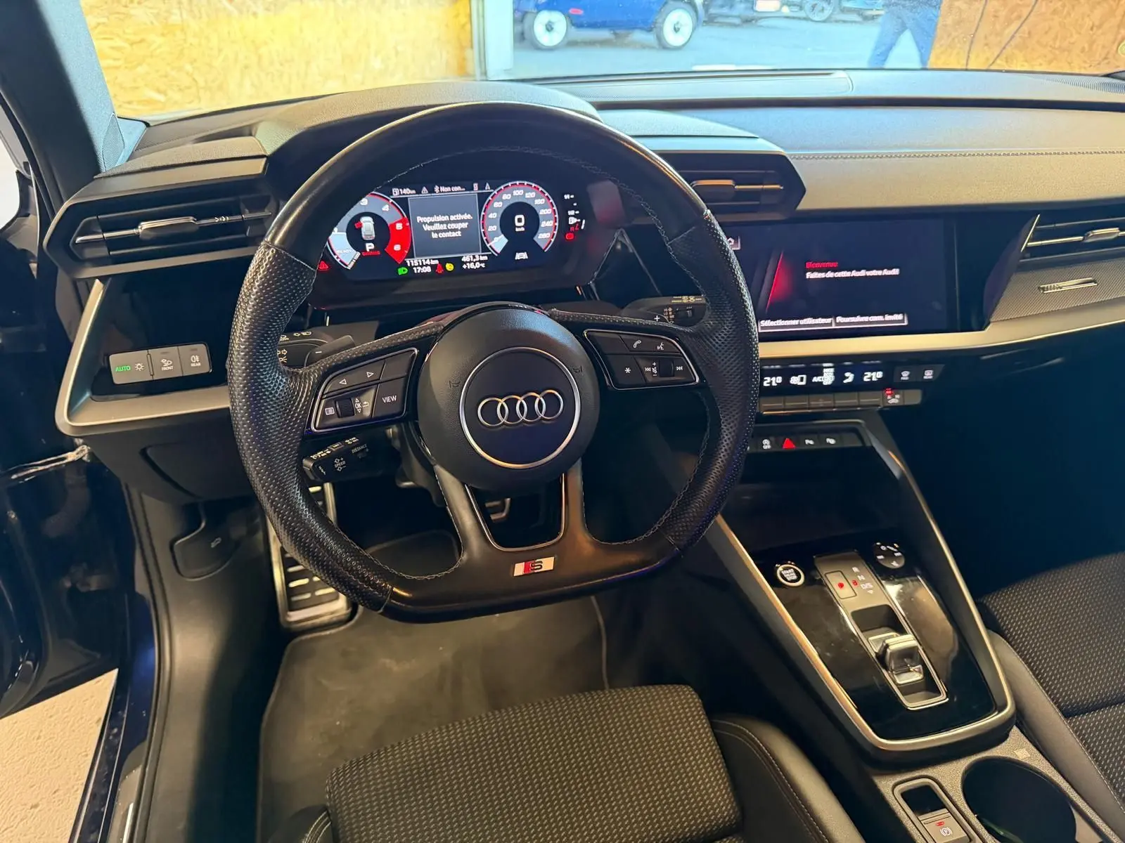 Intérieur noir de l'Audi A3 2.0 TDI 2022 vu du poste de conduite, avec volant S-Line et tableau de bord numérique.