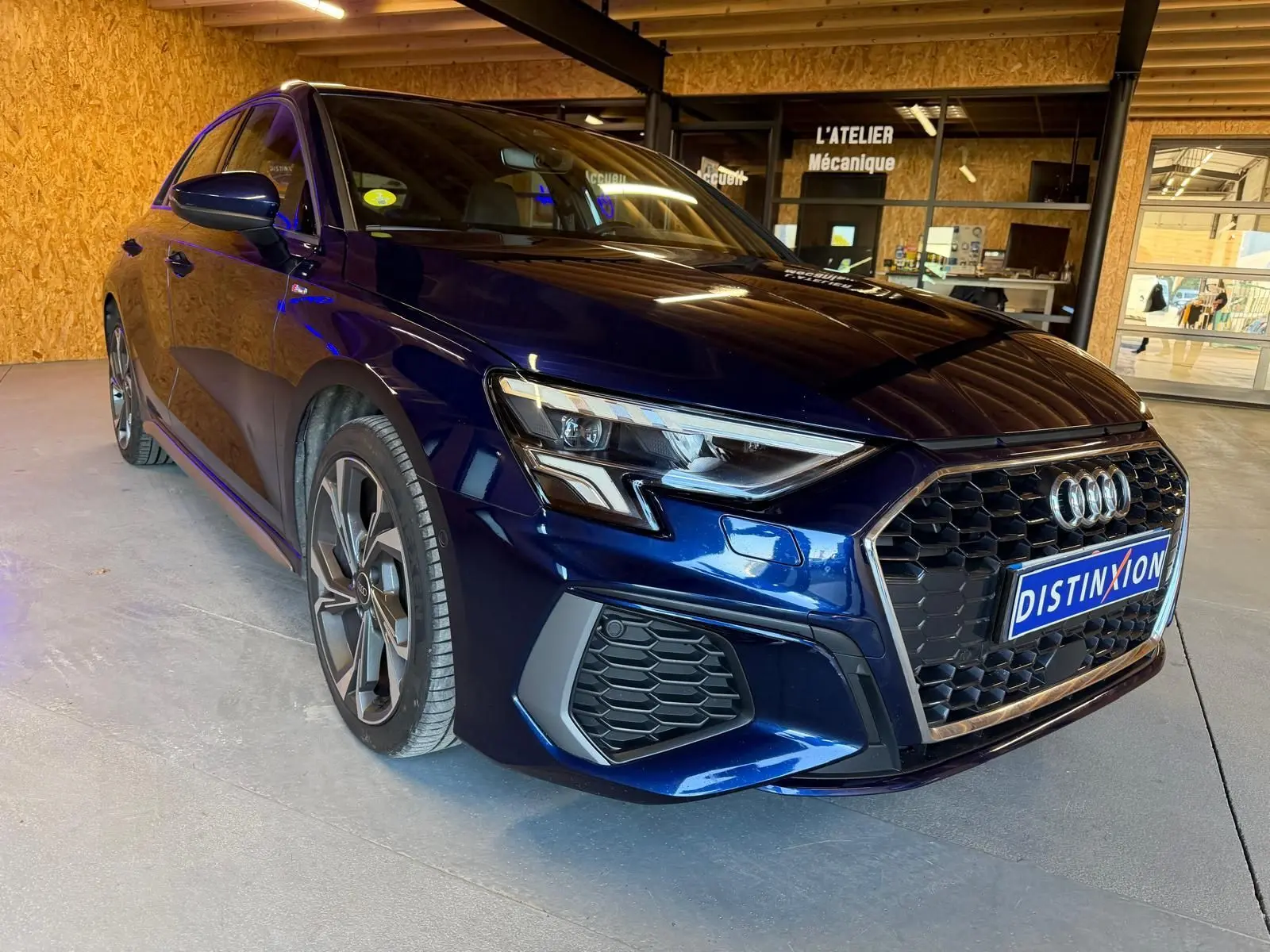Audi A3 2.0 TDI S-Line bleu vue 3/4 avant droit, avec calandre noire et jantes alliage distinctives.
