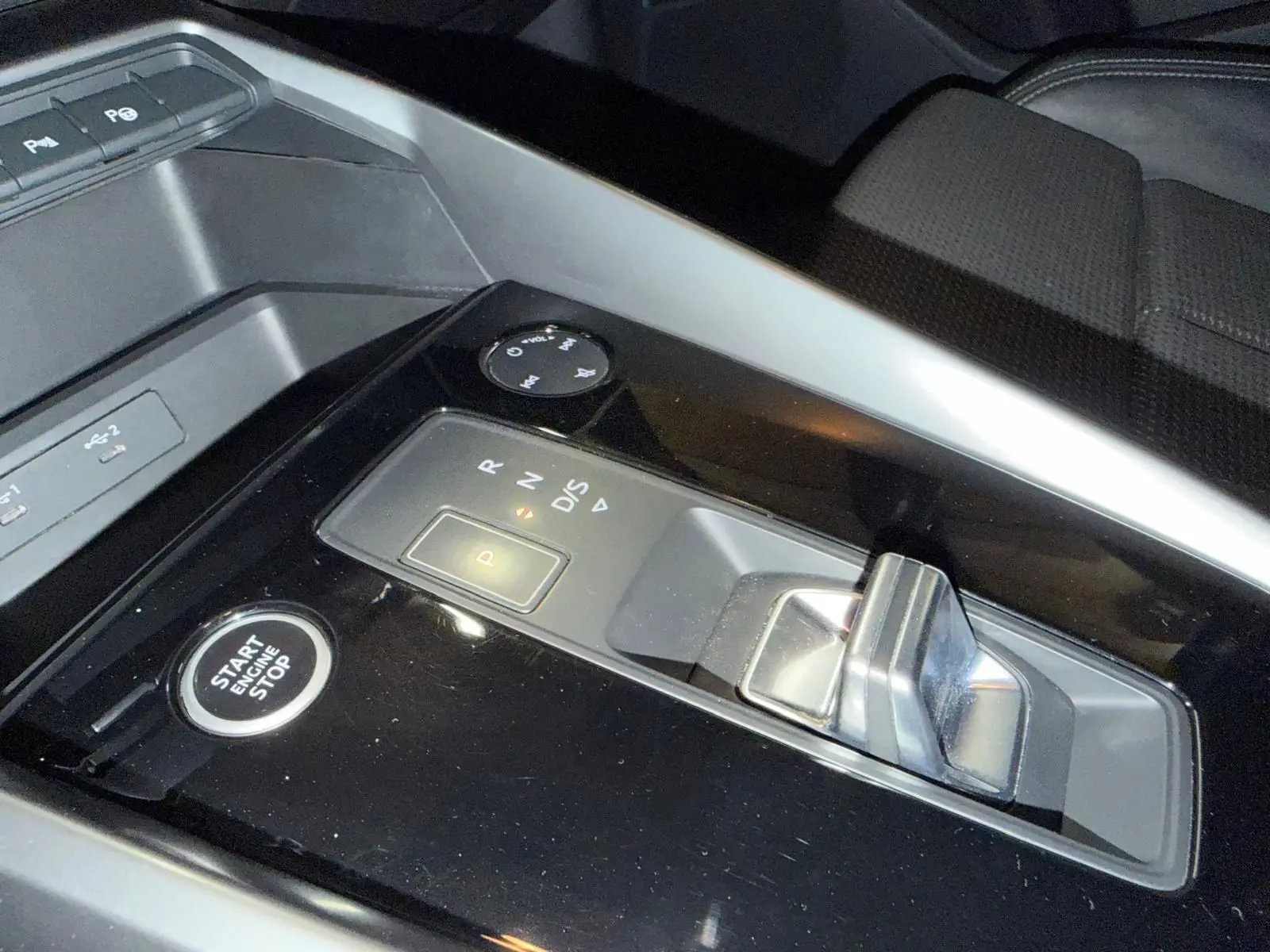 Gros plan sur la console centrale de l'Audi A3 2.0 TDI 150 S-TRONIC S-LINE, avec levier de boîte auto et bouton start/stop.