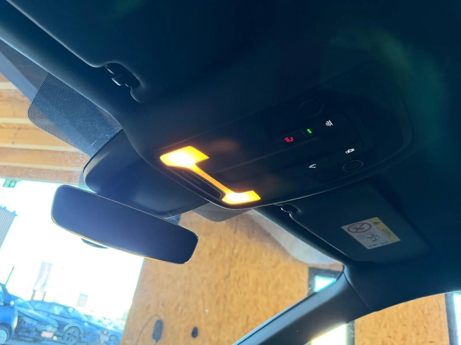 Vue intérieure du plafonnier et du rétroviseur central d'une Audi A3 bleu, avec éclairage allumé.