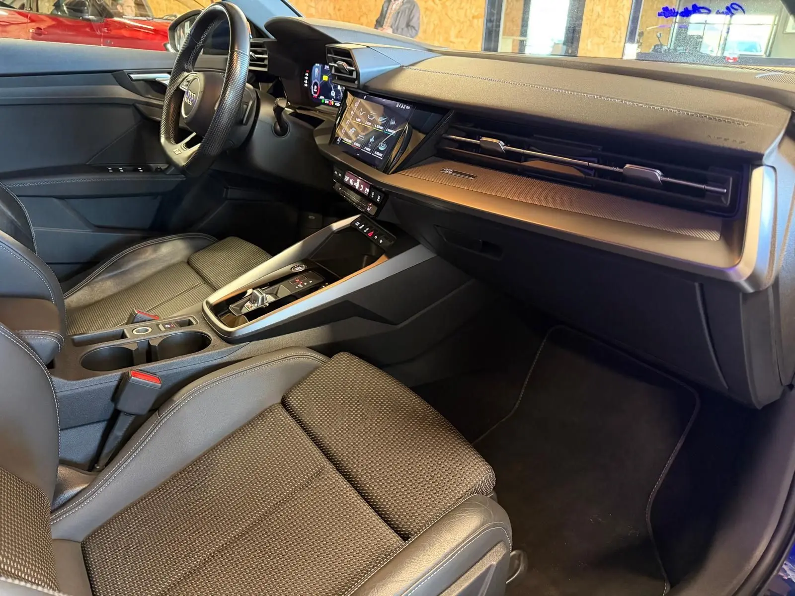 Intérieur noir de l'Audi A3 2.0 TDI 2022, vue côté passager montrant tableau de bord et console centrale moderne.