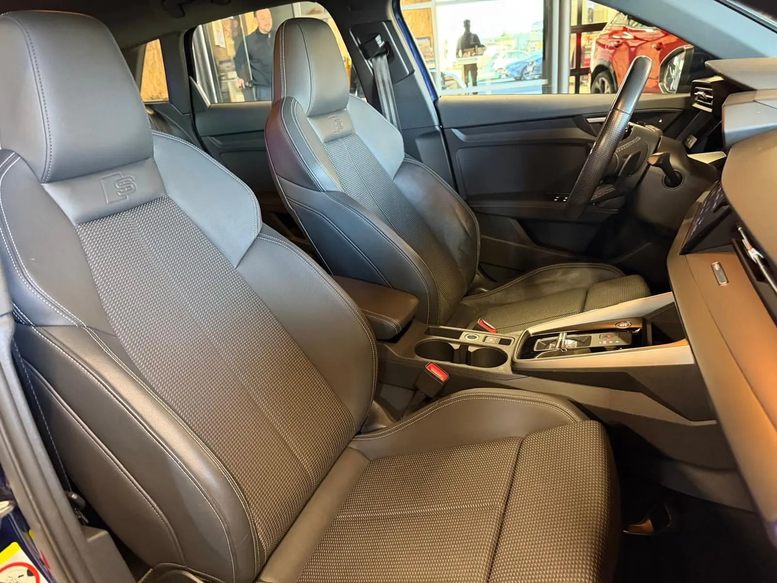 Vue intérieure côté conducteur de l'Audi A3 2.0 TDI S-Line 2022, sièges sport en cuir noir avec surpiqûres contrastées.