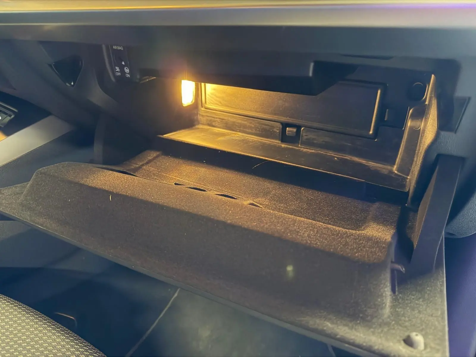 Intérieur de la boîte à gants ouverte avec éclairage, sur l'Audi A3 2.0 TDI S-Line bleu, vue côté passager.