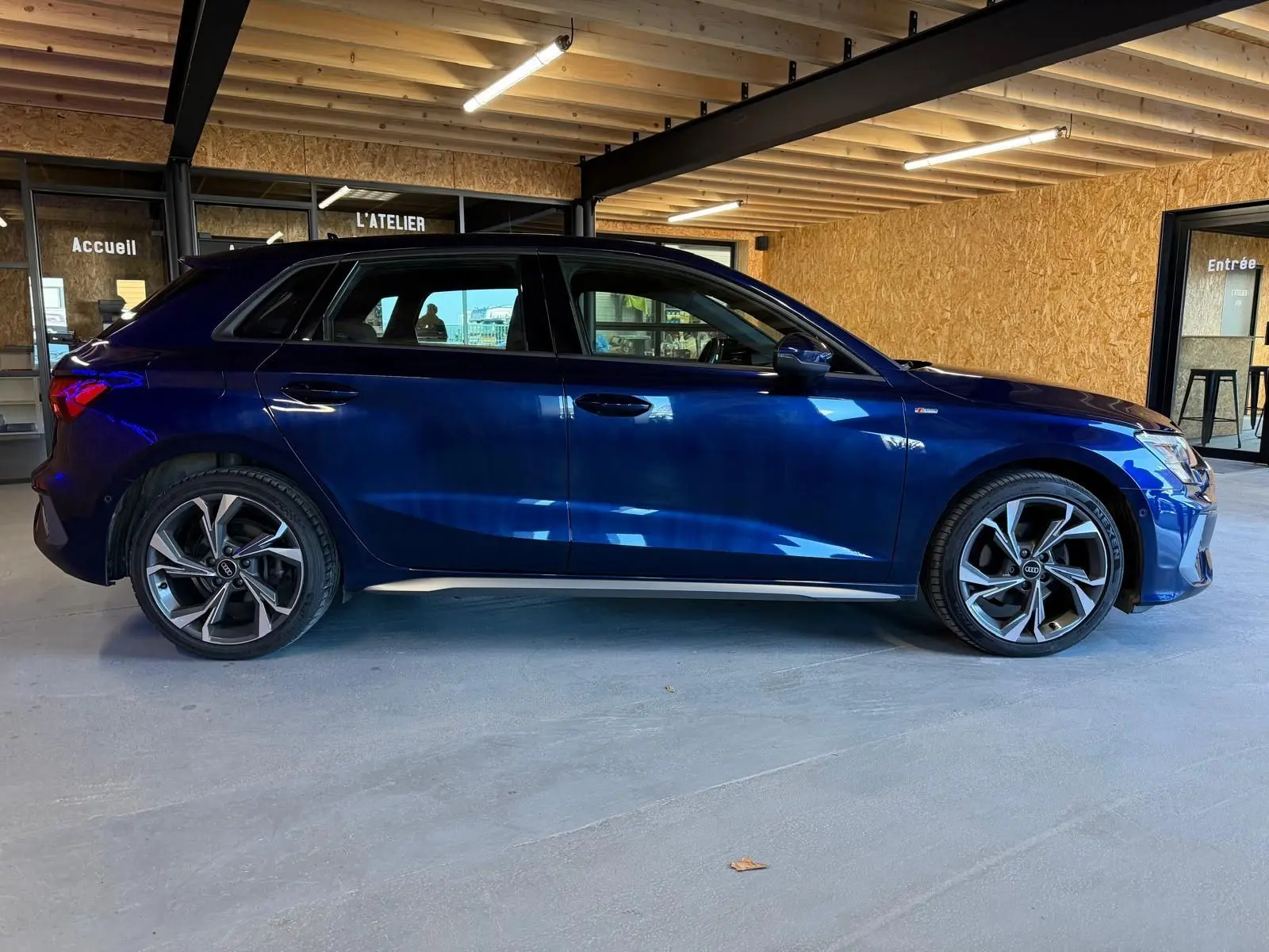 Audi A3 2.0 TDI S-Line bleu vue de profil côté gauche, avec jantes alliage et intérieur visible à travers les vitres.