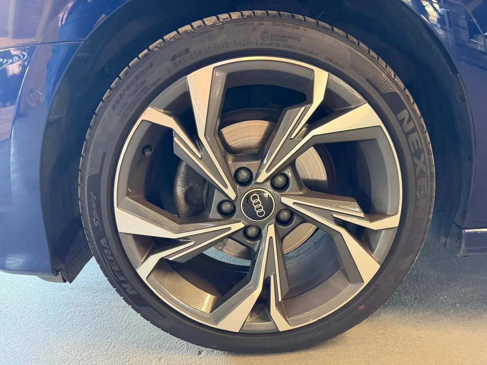 Gros plan sur la roue avant droite bleu foncé d’une Audi A3 2.0 TDI S-Line avec jante alliage à design géométrique.