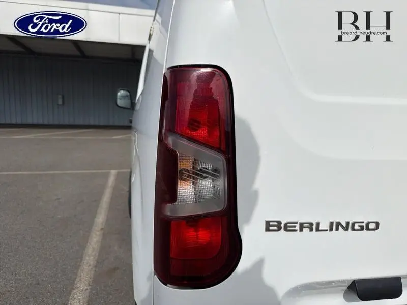 Gros plan sur le feu arrière droit et le logo Berlingo d’un utilitaire blanc banquise, vue arrière côté droit.