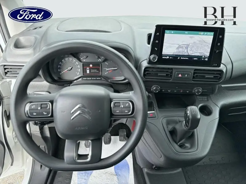 Vue intérieure centrée sur le volant multifonction et le tableau de bord du Citroën Berlingo Fourgon blanc avec écran tactile GPS.