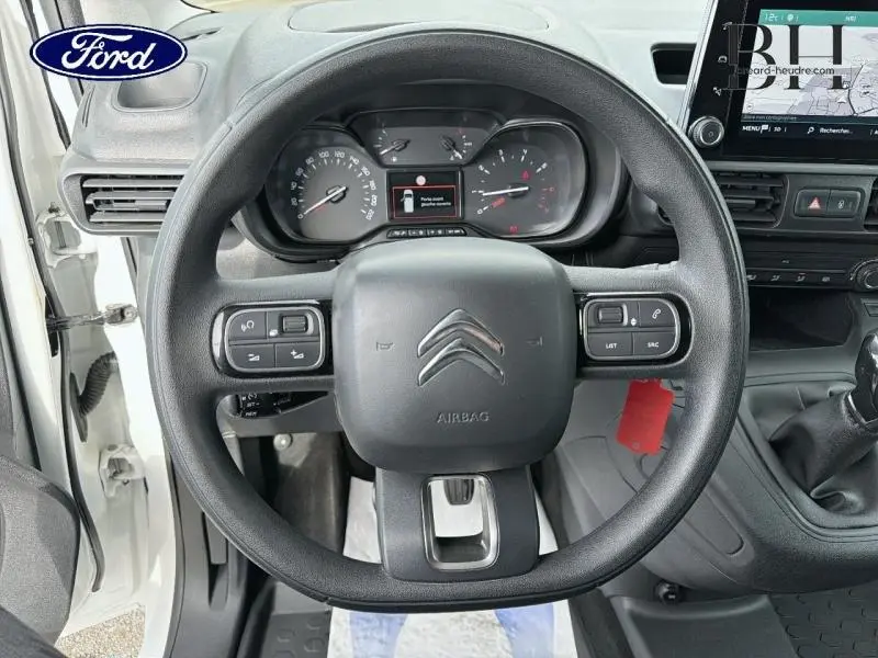 Vue rapprochée du volant multifonction noir et du tableau de bord du Citroën Berlingo Fourgon blanc Banquise 2020.